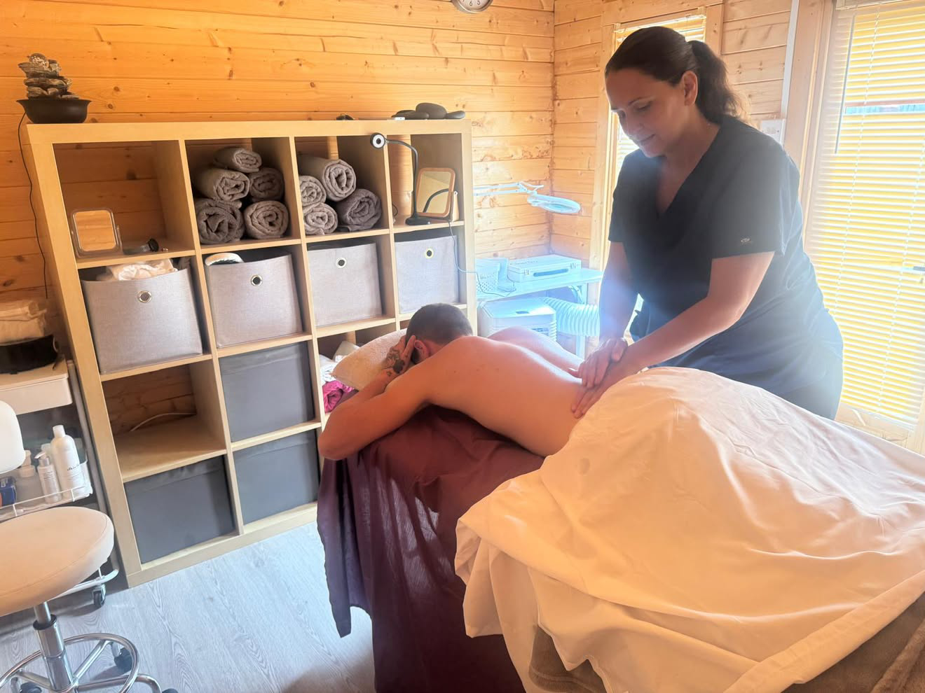 Bright, sunlit cabin interior with Diane treating a client